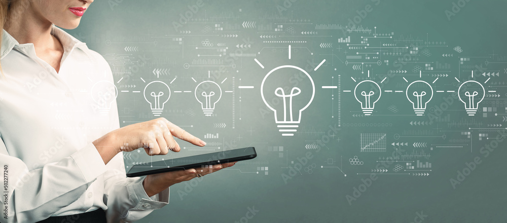 Idea light bulb theme with business woman using a tablet computer