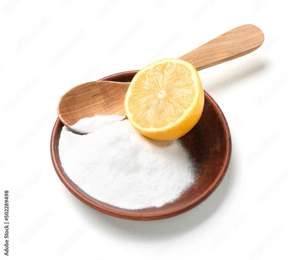 Bowl with baking soda and half of lemon on white background