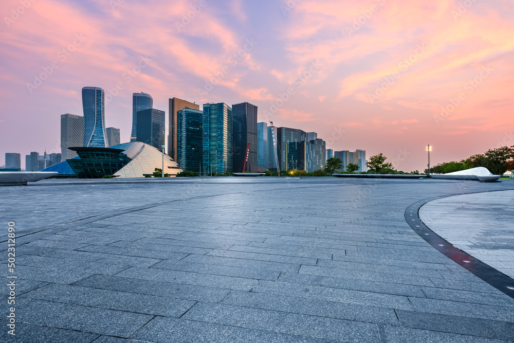 Empty square floor and city skyline with modern buildings in Hangzhou at sunset, China.