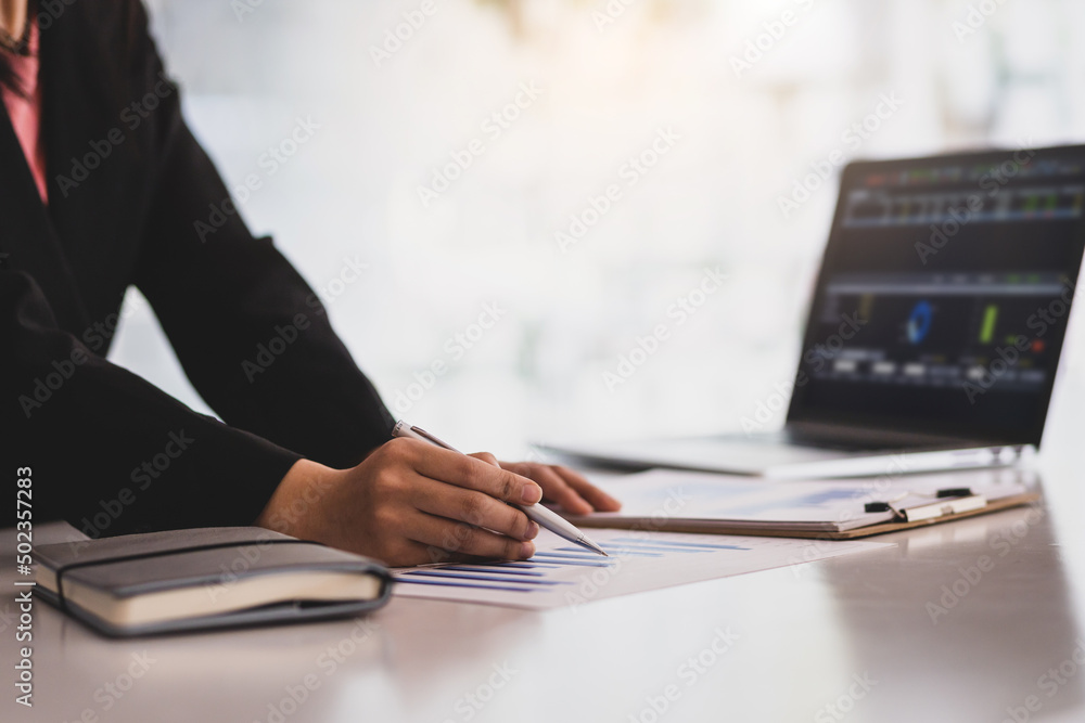 Businesswoman finance market analyst working on laptop pointing at analyzing business finance report