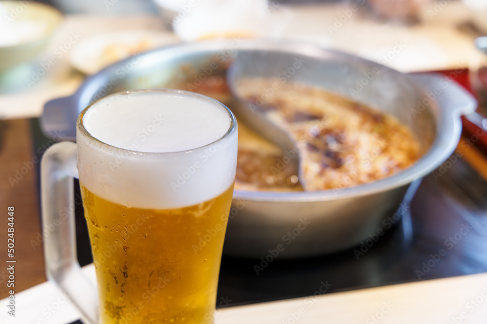 鉄鍋で作る美味しそうな料理と冷えた生ビール