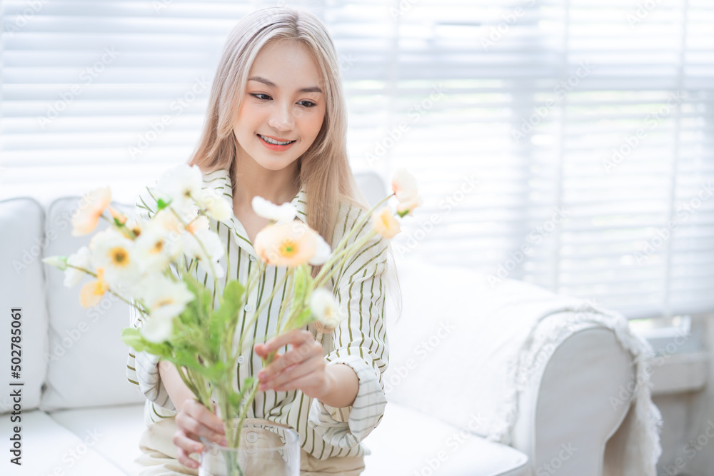 亚洲年轻女子在客厅插花