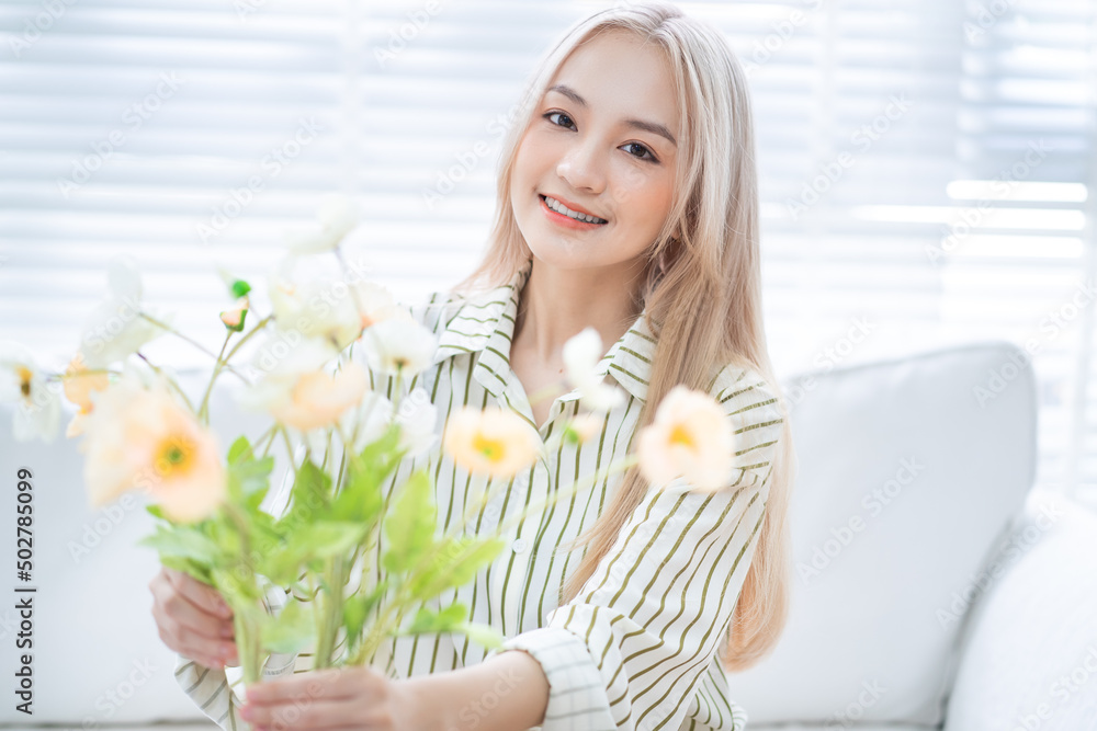 亚洲年轻女子在客厅插花