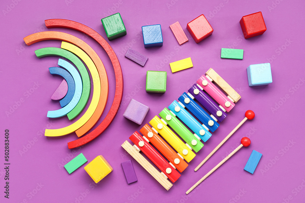 Wooden cubes with blocks and xylophone on purple background