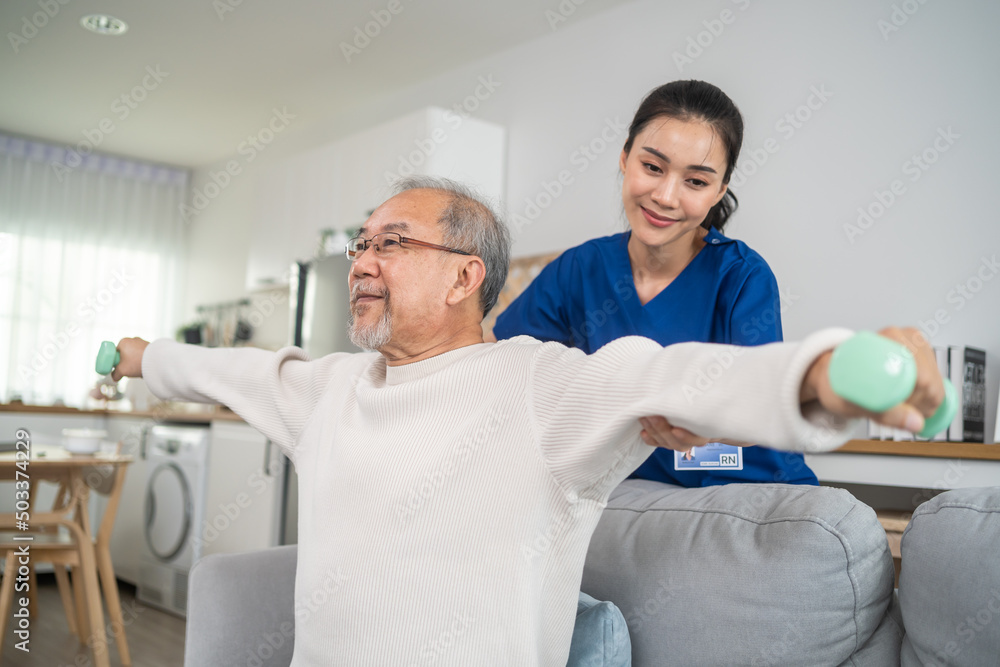 Asian older aged man doing physiotherapist with support from nurse. 