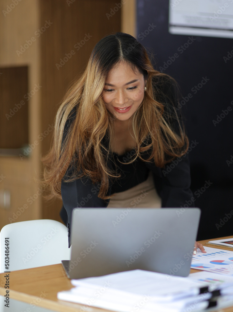 有魅力的女商人或漂亮的经理在des上处理笔记本电脑和财务文件