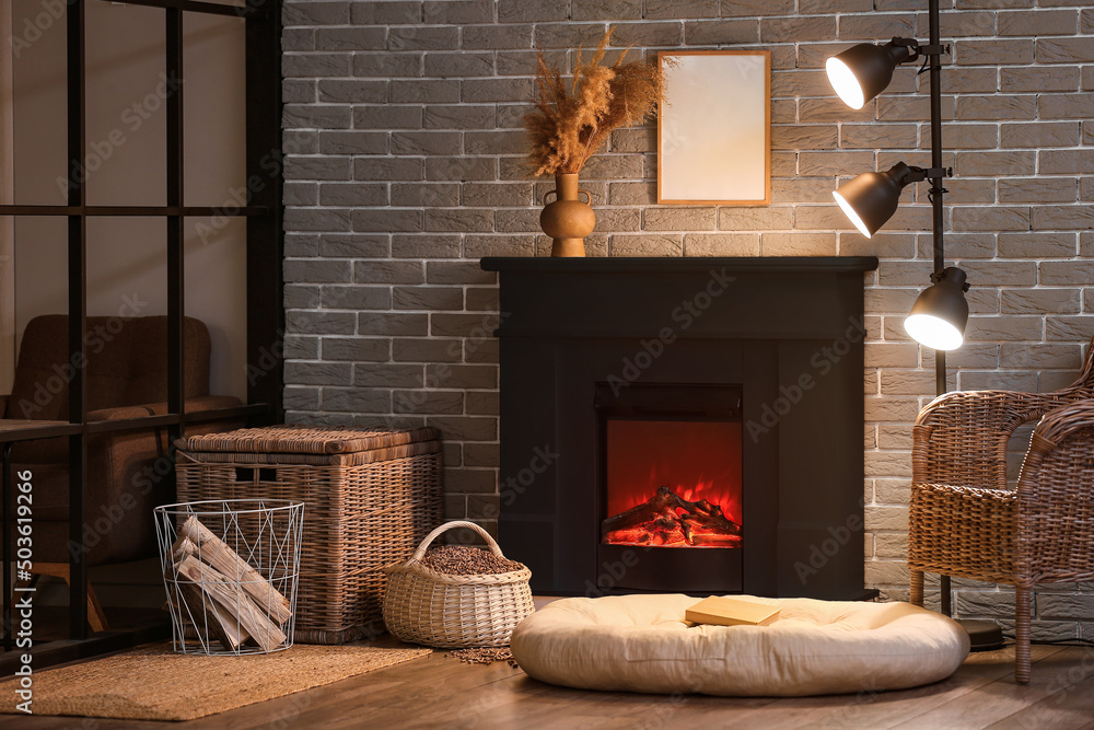 Interior of modern living room with black fireplace near brick wall