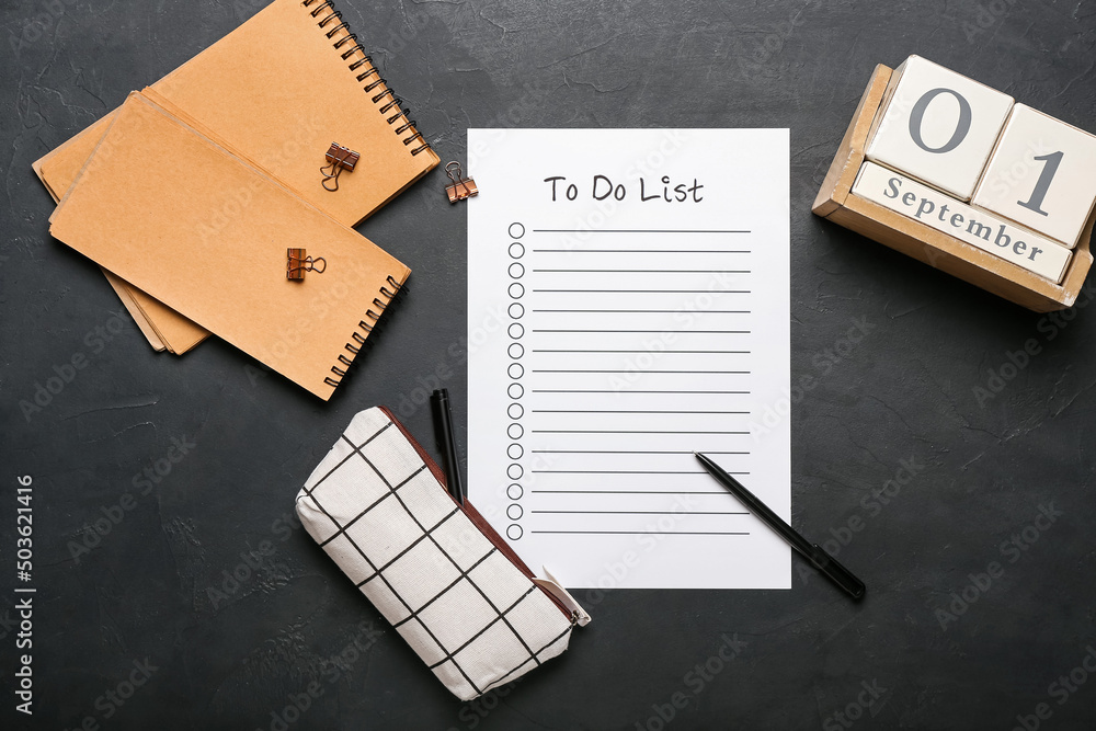 Blank to do list, notebook, calendar and pencil case with stationery supplies on dark background