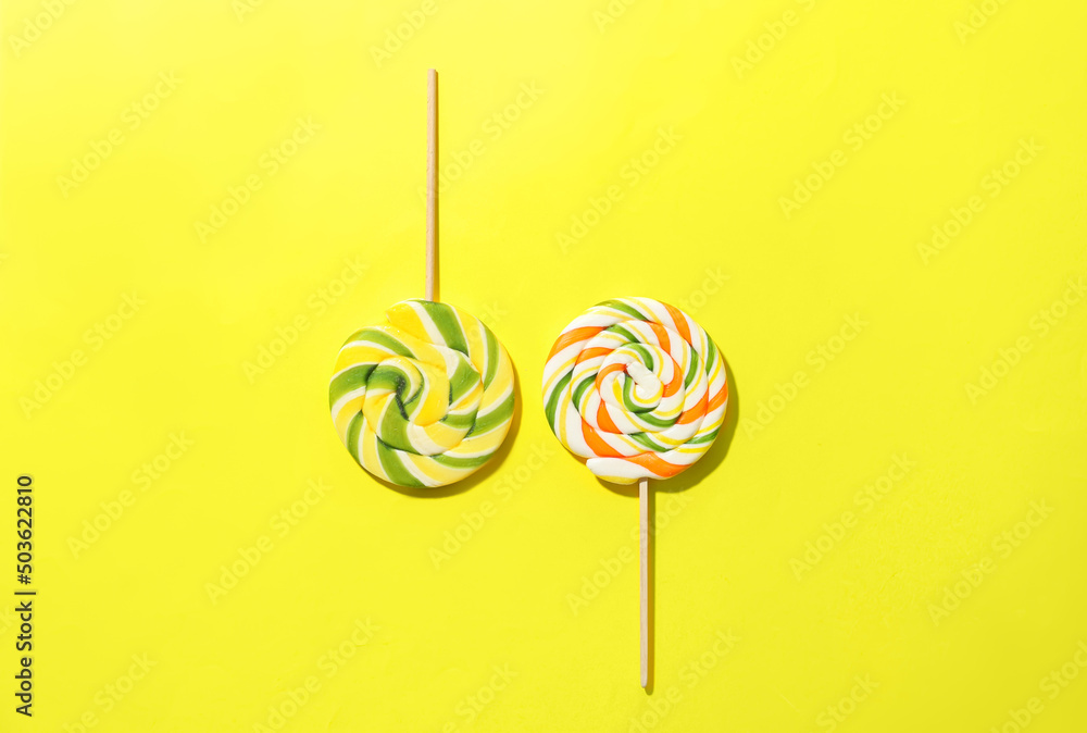 Sweet lollipops on yellow background