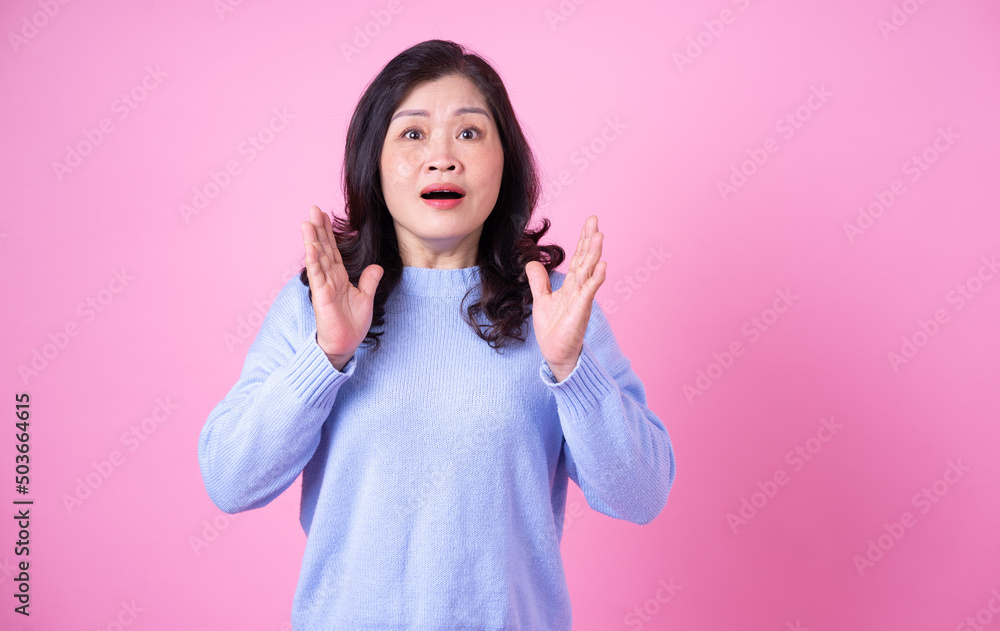 Portrait of middle aged Asian woman on pink background
