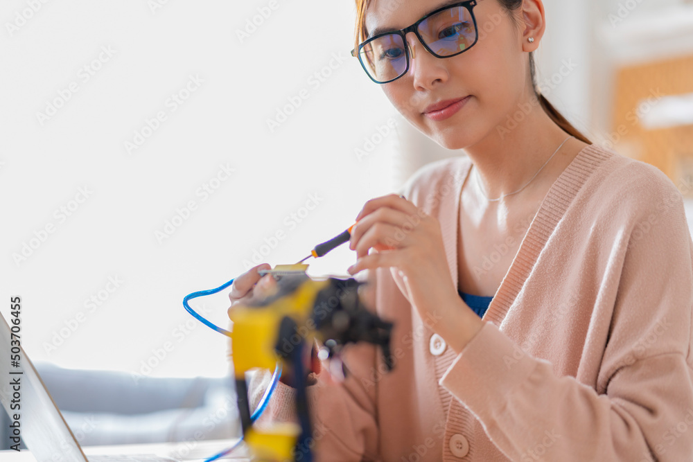 聪明的亚洲女程序员学习STEM中的机械臂ai编码电子板电缆，STEAM she