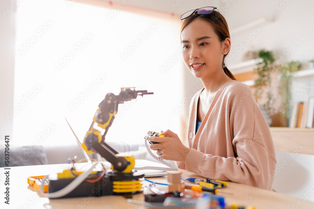 聪明的亚洲女程序员学习STEM中的机械臂ai编码电子板电缆，STEAM she