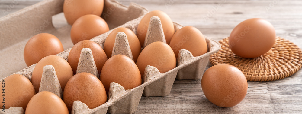 Fresh brown chicken eggs in a kraft paper egg carton.