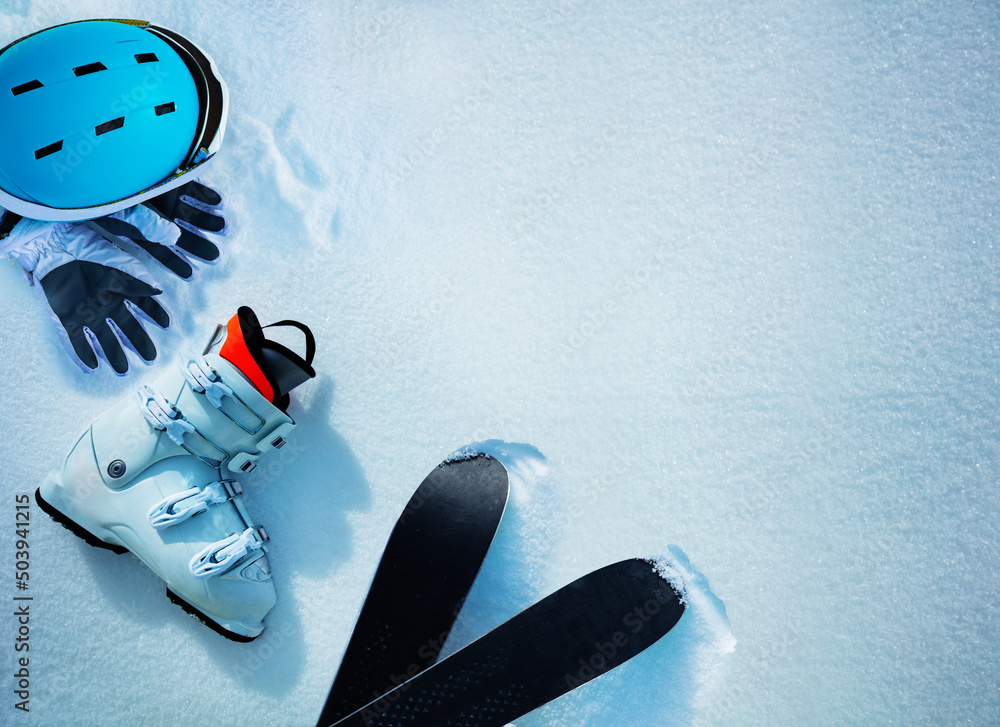 White alpine ski boot helmet and gloves in snow from above