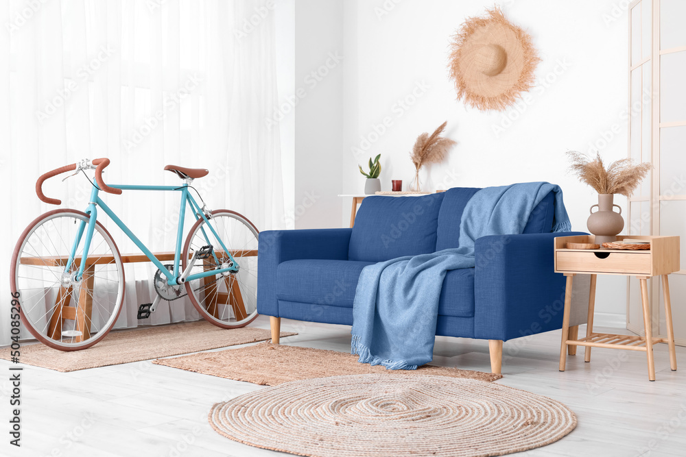 Comfortable sofa, bicycle and table in stylish living room