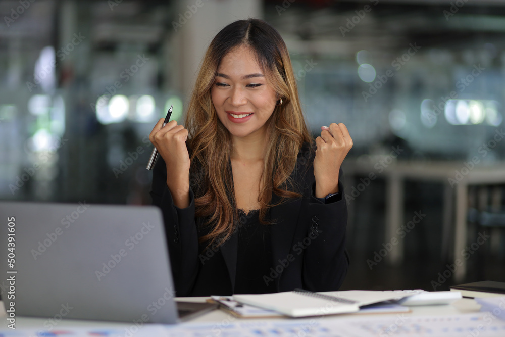 一位在笔记本电脑上工作的商务女性或秘书看着笔记本电脑尖叫时表达了她的喜悦