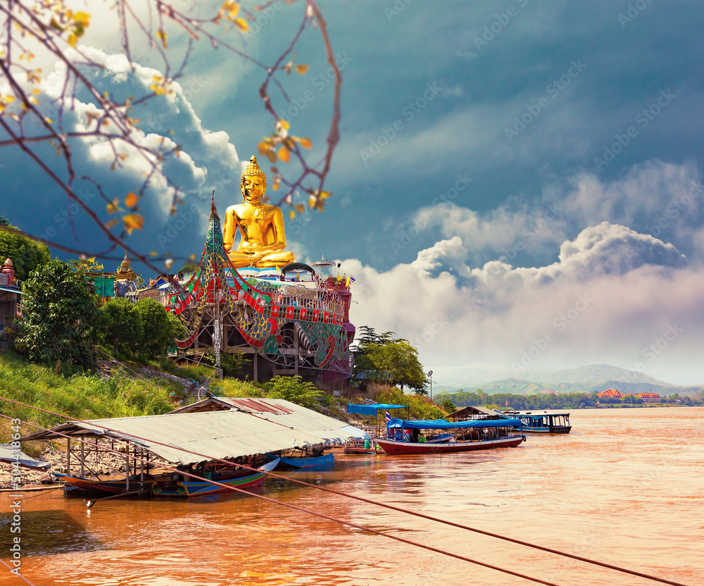 Estatua dorada de Buda gigante en el río Mekong. Hermoso amanecer en el río Mekong con barcos, front