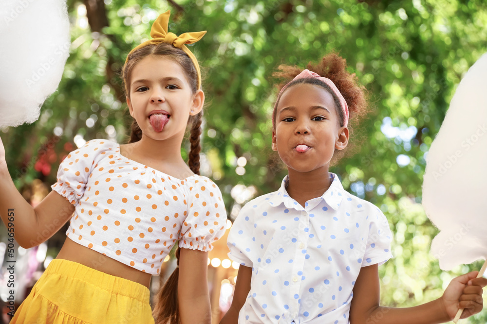 Cute little girls with cotton candy outdoors