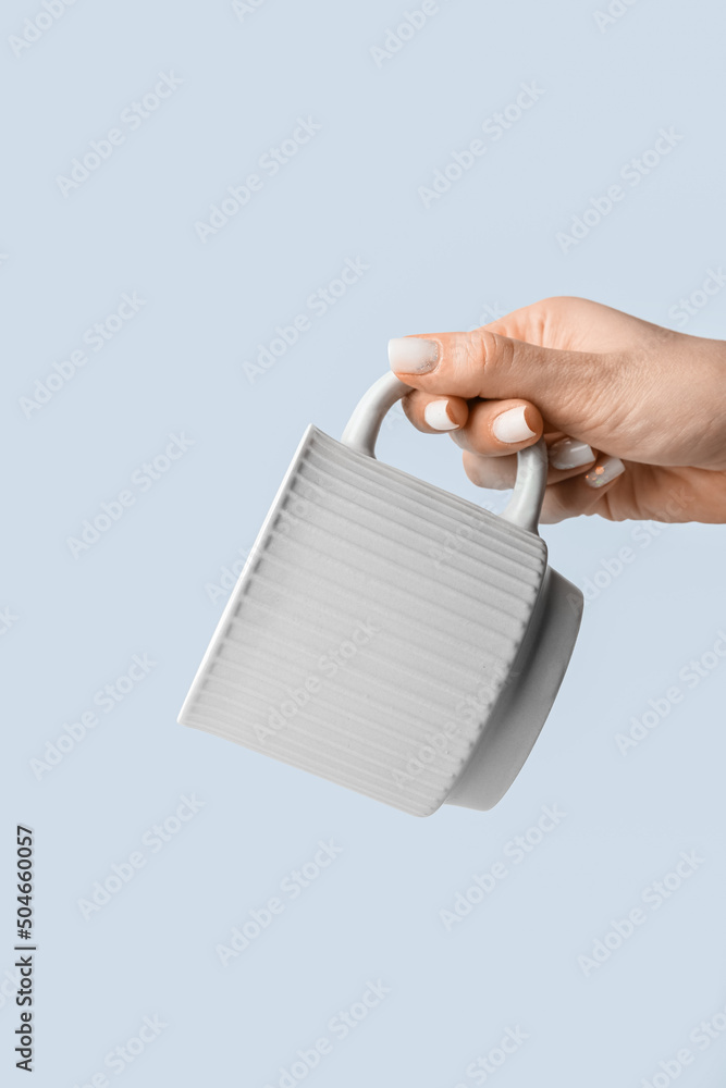 Woman holding ceramic cup on light background, closeup