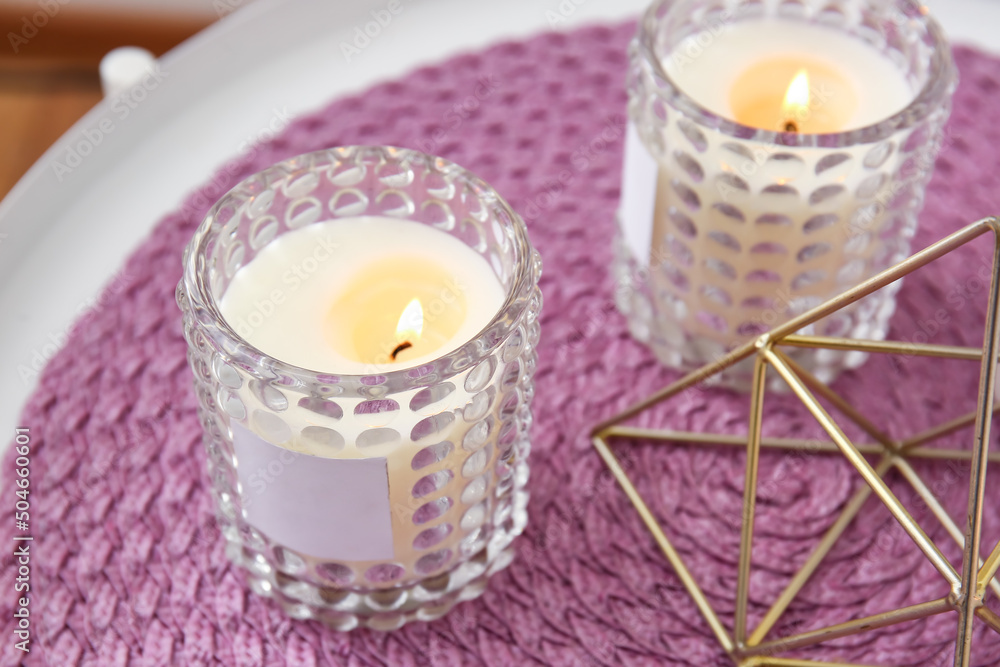 Holders with burning candles on table, closeup