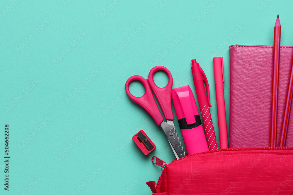 Red pencil case with stationery supplies on blue background