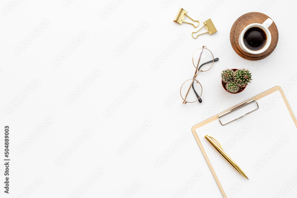 White office desk table with empty paper on clipboard