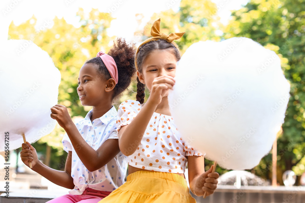 Cute little girls with cotton candy outdoors