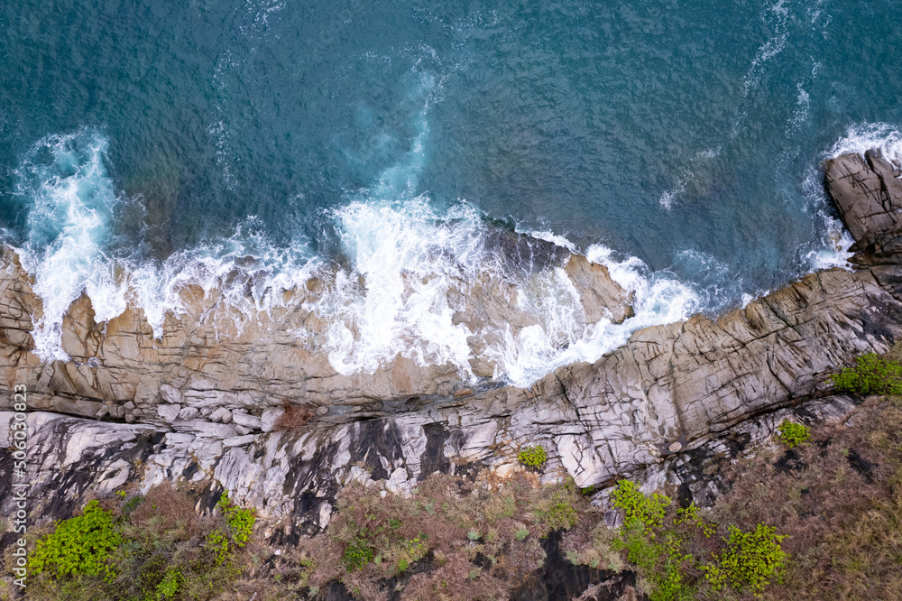 鸟瞰图自上而下，海浪拍打着海岸，阳光明媚，美丽的绿松石海面