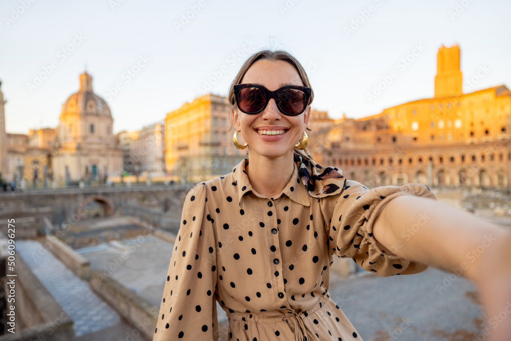 Happy woman taking selfie photo on the background of Roman forum. Style caucasian woman in dress and