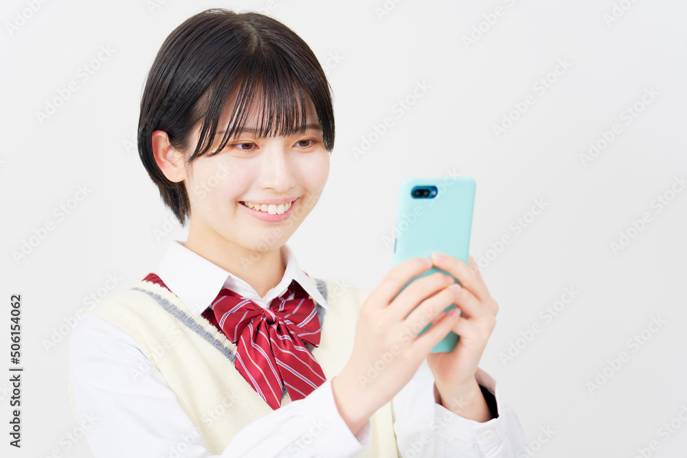 白背景でスマホを使う女子高生