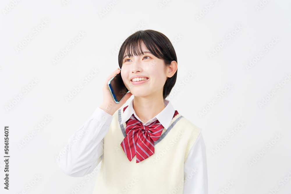 白背景でスマホで電話する女子高生