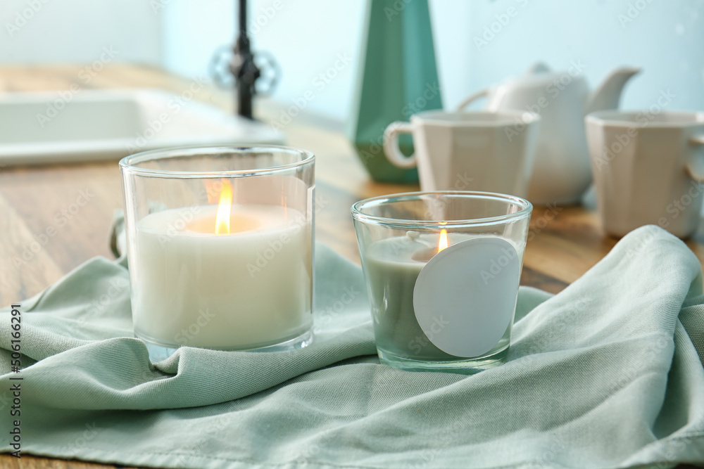 Holders with burning candles on table, closeup