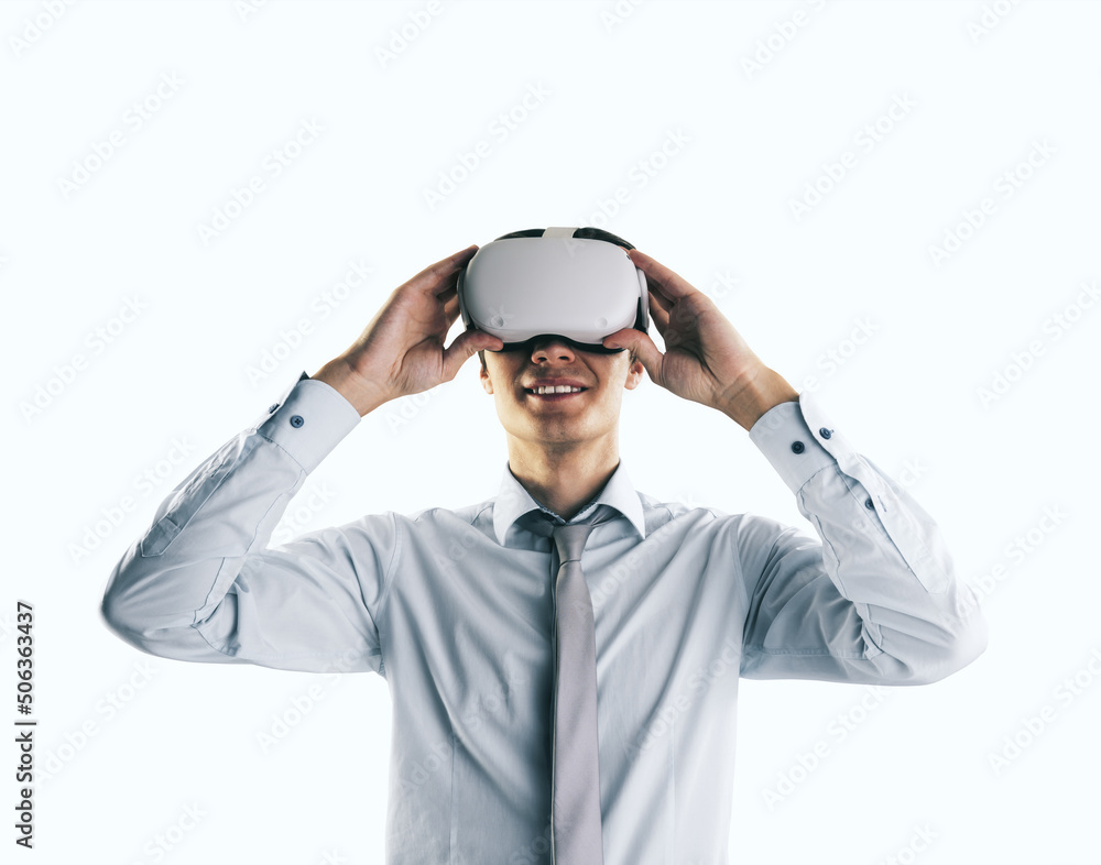 Virtual reality concept with young businessman gets new emotions in VR glasses on his head on abstra