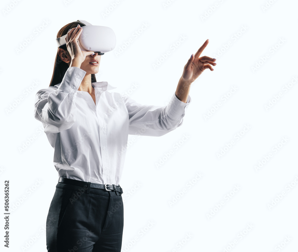 Young businesswoman working in virtual reality environment in VR glasses, presses by her finger on v