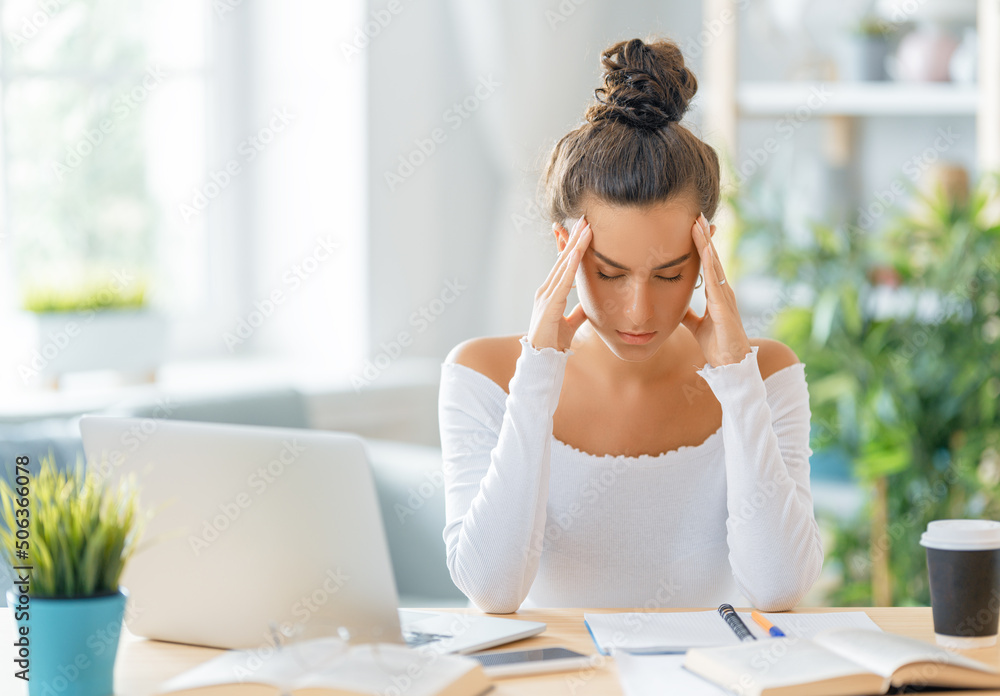 Young woman studying and having a head ache