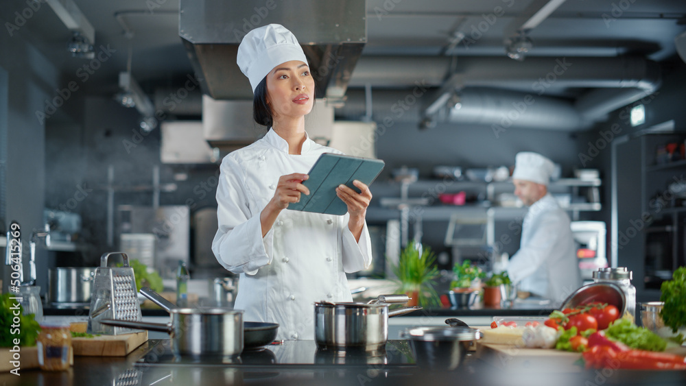 世界著名餐厅：亚洲女厨师烹饪美味正宗的食物，使用数字平板电脑