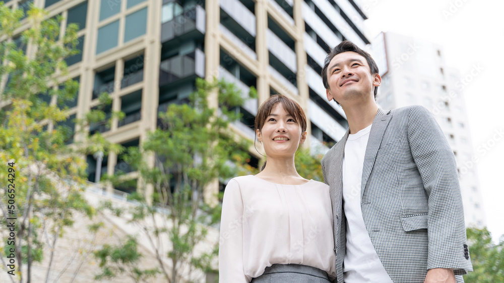 タワマンの前に立つカップルのポートレート