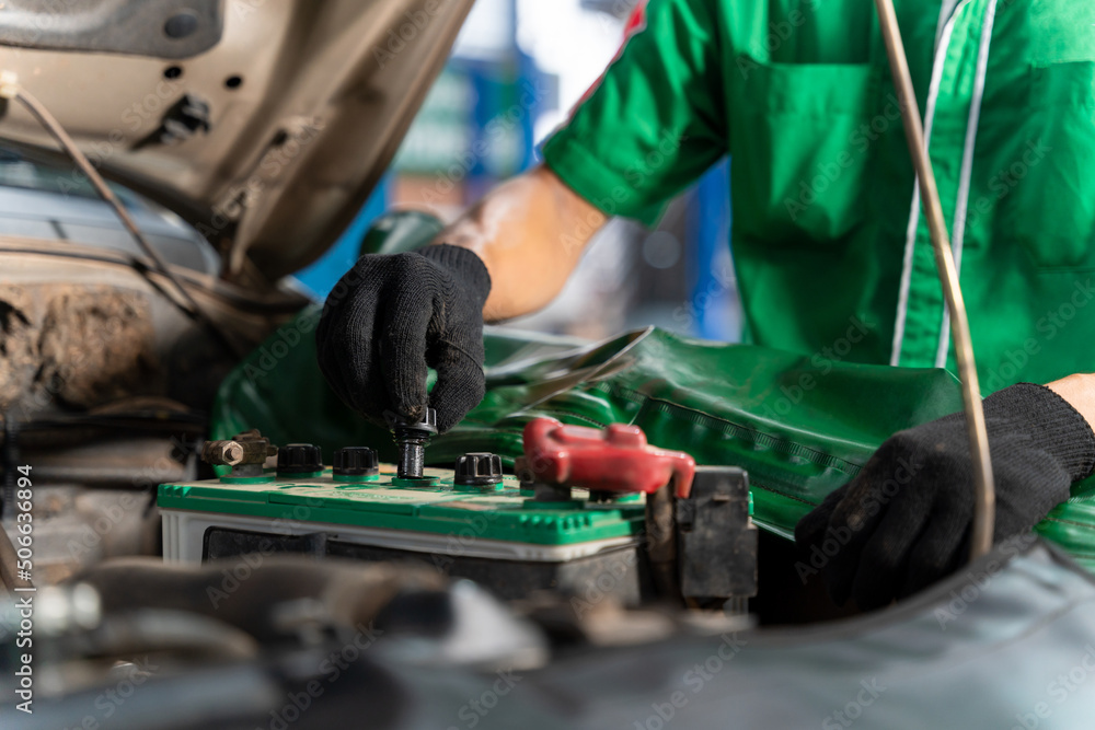 Auto mechanic checking battery for the customers who come to use the battery replacement service at 