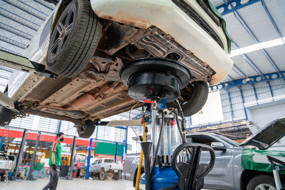 A car that comes to change the engine oil in Car repair station paved with epoxy floor and electric 