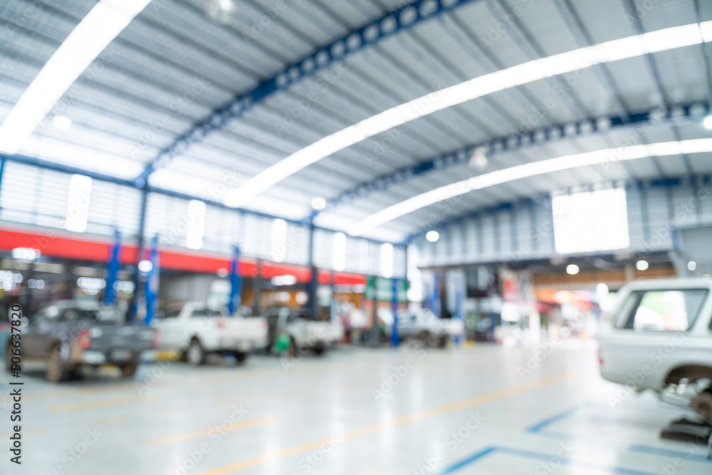 Blurred of Auto mechanic working in Car repair station paved with epoxy floor and electric lift for 