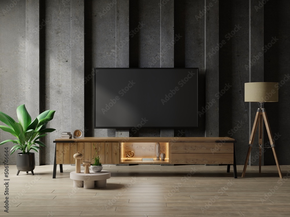 TV in modern living room with table and plant on concrete wall background.