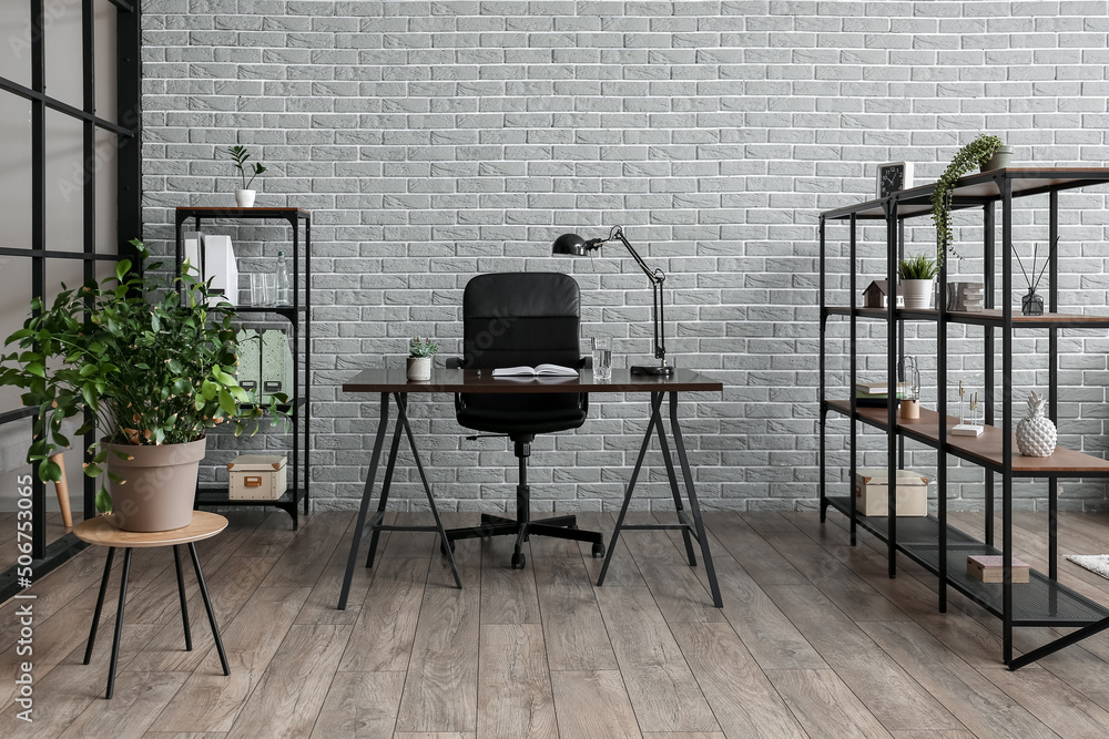 Interior of modern office with opened book and glass of water on table