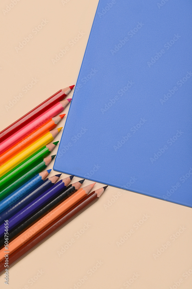 Colorful pencils on beige and blue background