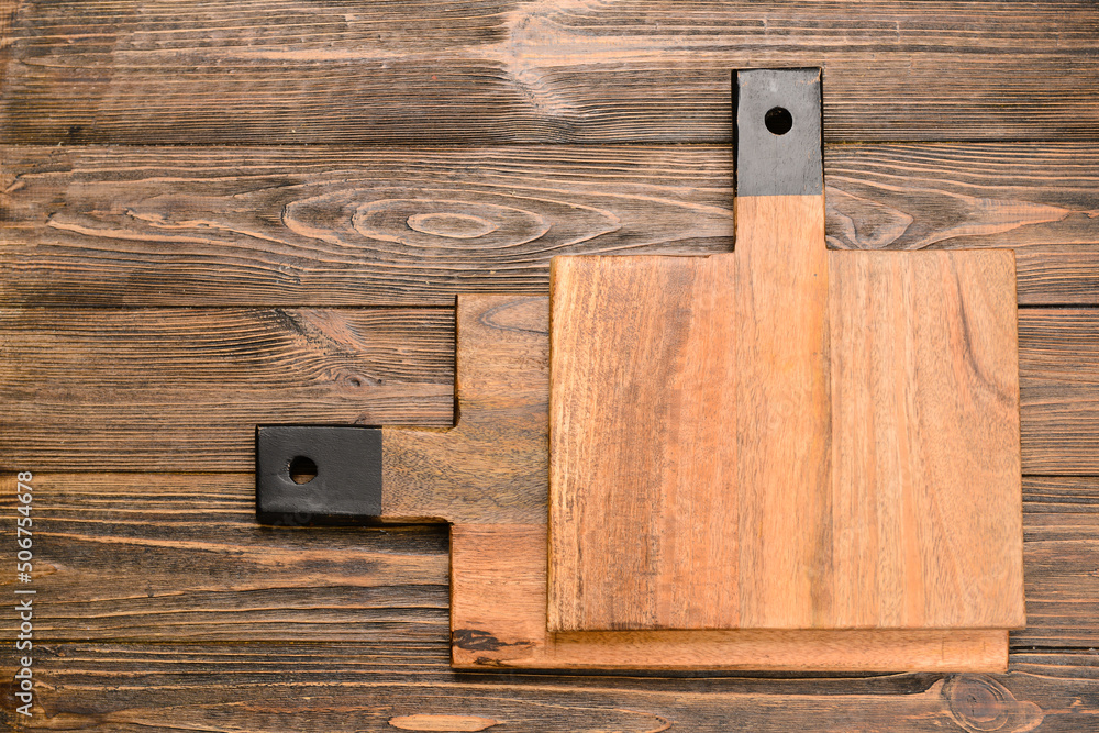 Cutting boards on wooden background, top view