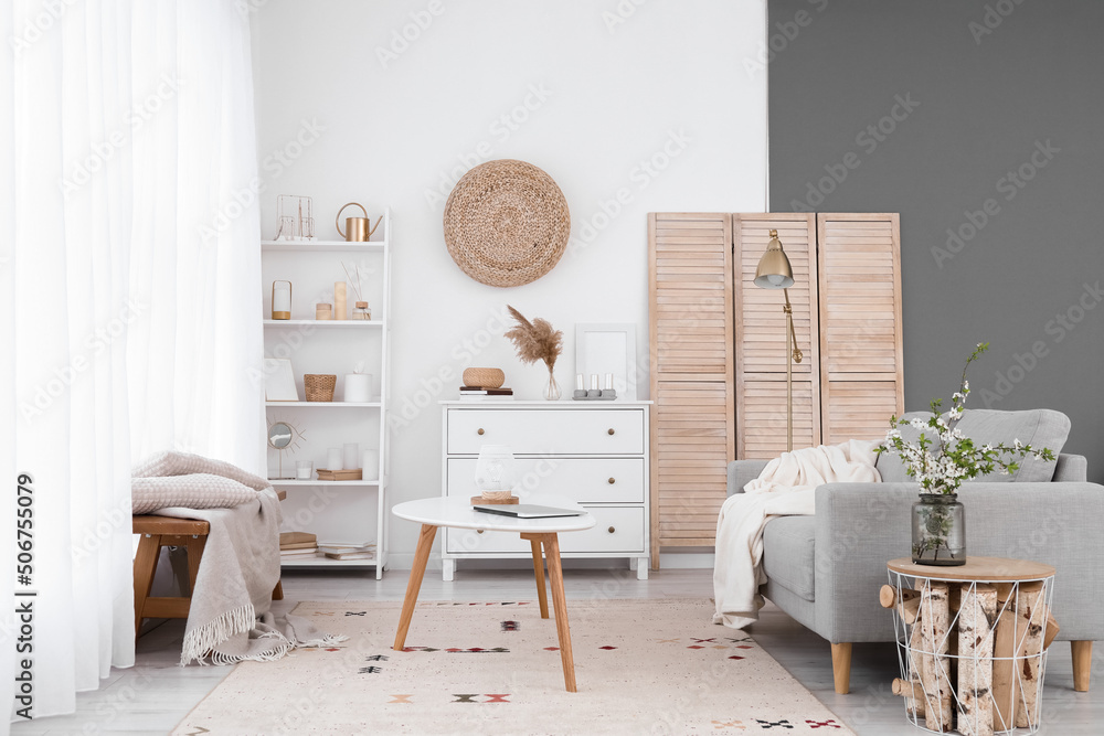 Interior of light living room with sofa, bench and shelving unit