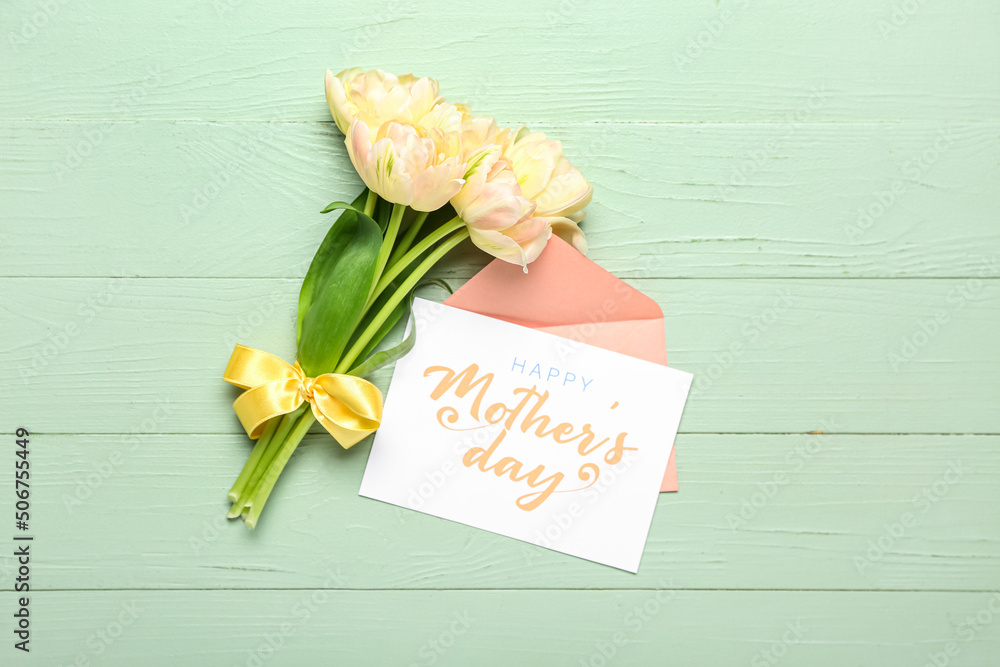 Card with text HAPPY MOTHERS DAY, envelope and flowers on color wooden background