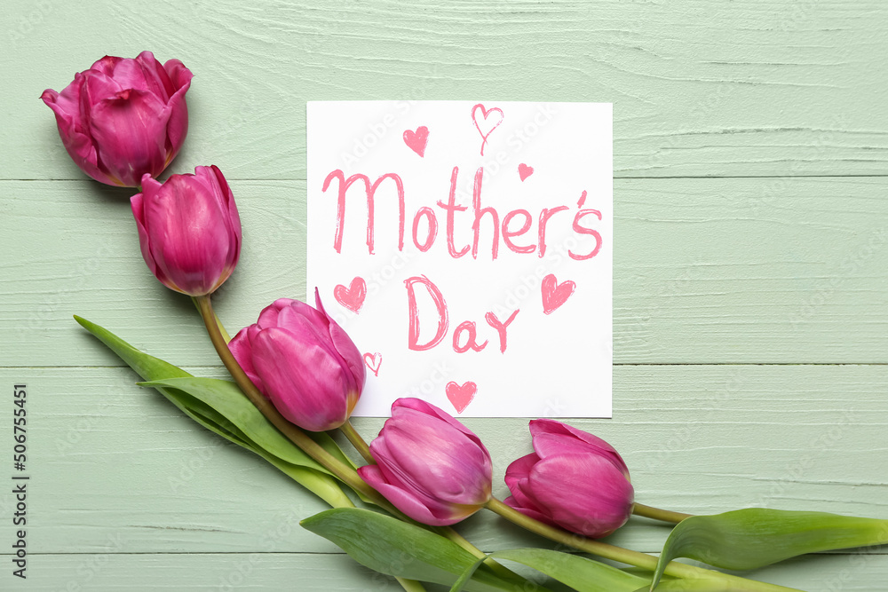 Card with text MOTHERS DAY and pink tulips on color wooden background