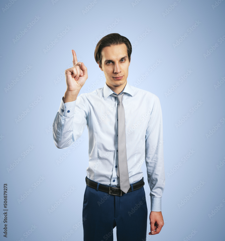 Warning concept wih young handsome man in white shirt with raising hand and forefinger isolated on l