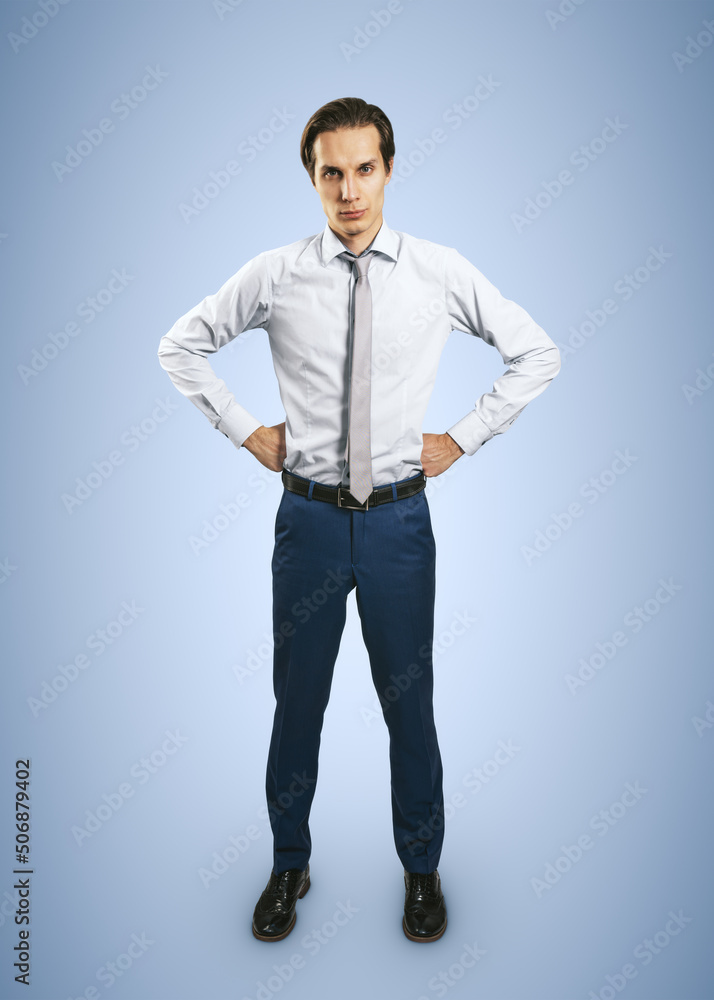 Strength concept with confident young man looking at you isolated on light blue background