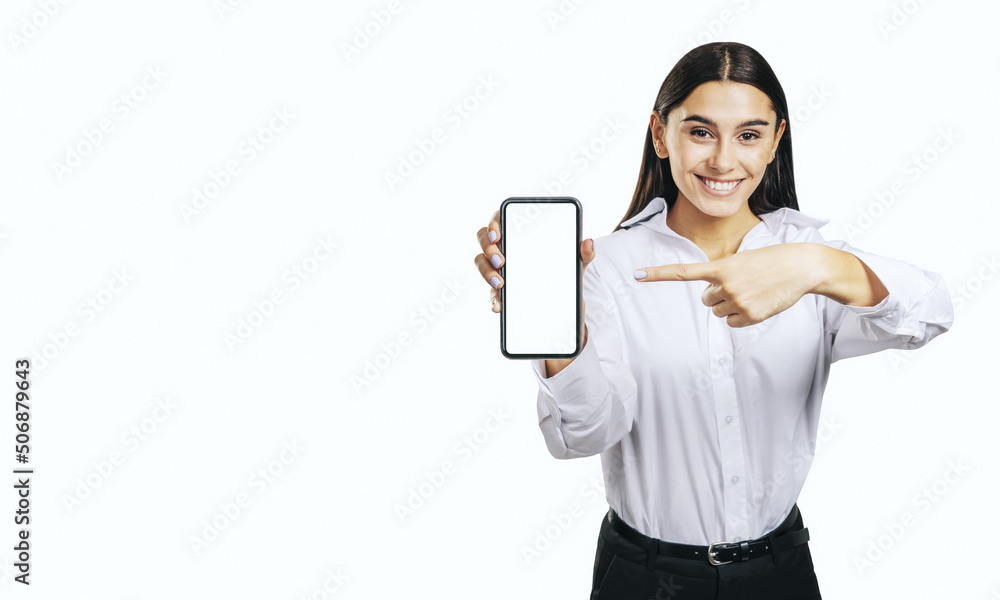 Mobile application concept with happy girl in white shirt showing modern smartphone with white blank